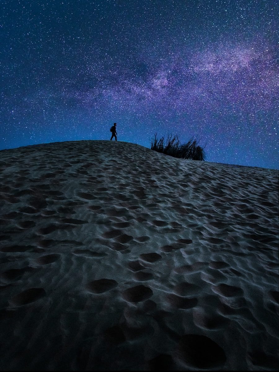 person standing on sand under blue sky during daytime
